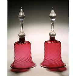 A pair of cranberry models of hand-bells, spirally fluted and applied with an opaque-white rim, f...