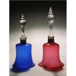 Two models of hand bells, one with a blue bell, the other cranberry, both spirally moulded and wi...