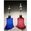 Two models of hand bells, one with a blue bell, the other cranberry, both spirally moulded and wi...