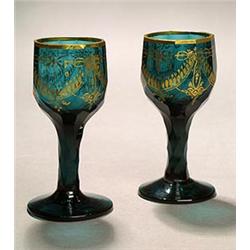 A set of ten Bohemian facetted green and gilt wine glasses, the fluted ovoid bowls with a foliate...