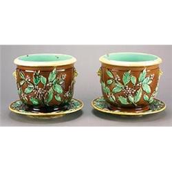 A pair of majolica jardinières and stands, each moulded in relief with berried holly and a pair o...