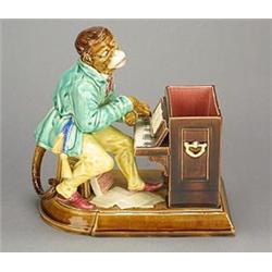 A Sarreguesmines majolica tobacco box, modelled as a monkey playing an upright piano, painted wit...