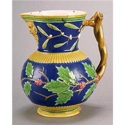 A Minton majolica blue-ground mask jug, of globular form with flared neck, the body moulded in re...