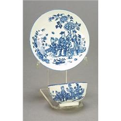 A Worcester blue and white teabowl and saucer, printed with three Chinese figures on a garden ter...