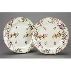 A pair of Miles Mason octagonal porcelain plates, painted in puce, iron-red, and green with scatt...