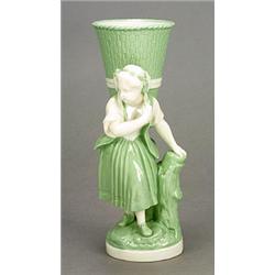 A Minton 'Celadon'and white porcelain figural posy holder, modelled as a girl with a large basket...