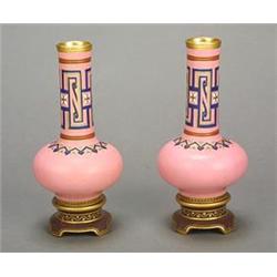 A pair of Minton Japonaiserie pink-ground vases, with tall cylindrical necks above compressed glo...