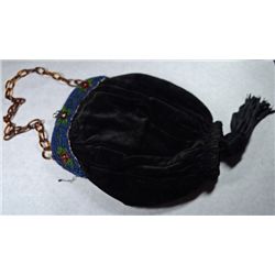 VELOUR CLUTCH PURSE WITH BEAD WORK AT THE TOP. a TASSEL ON THE BOTTOM.