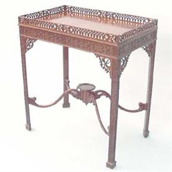 An Edwardian Chippendale style mahogany silver table having pierced gallery over blind fret-carve...