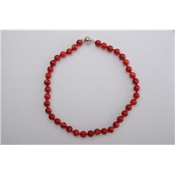 One red coral bead necklace 10.5mm diameter  with a polished silver clasp. Est.:$15-30