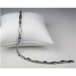 Sleek 10 karat white gold ladies bracelet set  with 8 oval Tanzanites and side diamonds  weighing ap