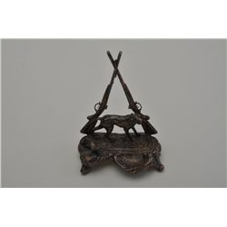 Silver over brass pen stand for desk –  hunting dog with crossed shotguns.   Est.:   $150-$300.