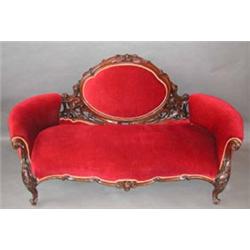 A good Victorian carved mahogany framed upholstered sofa with oval back and...