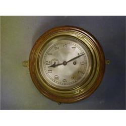 A ward room style clock, the 7" silvered dial with Arabic numerals contained in a circular gilt m...