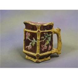 A 19th Century triangular  Majolica jug with pink glazed interior, the exterior decorated with fl...
