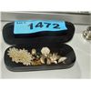 Image 1 : Black sunglass case filled with assorted brooches