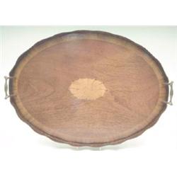 A Sheraton style oval cross banded mahogany tray with undulating rim, brass handles and inlaid ba...