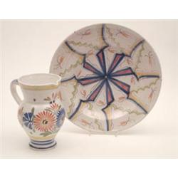 An Henriot, Quimper faience jug painted with stylised flowers, 8ins and a faience charger, simila...
