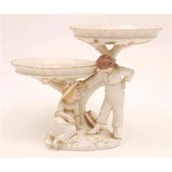 A Victorian Royal Worcester sweetmeat dish, 2-tiers supported on tree stem with boy and girl figu...