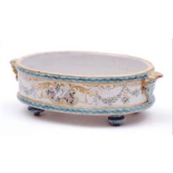 A 19th century French faience oval dish painted with a dove, cornucopia and foliage in polychrome...