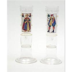 A pair of German cylindrical glass measures enamelled with characters and script, 9.75ins £100-15...