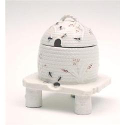 A Belleek first period honey pot and cover, moulded in the form of a bee-hive and painted with be...
