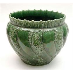 An early 20th century green glazed earthenware jardiniere, gadrooned and moulded with leaf scroll...
