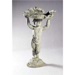 A lead bird bath, in the form of a shell and bird, supported by a putto with arms aloft, on a nat...