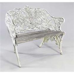 A Victorian iron garden bench cast overall with interlaced fern, with slatted wood seat on natura...