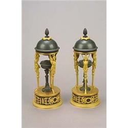 A pair of bronzed and gilt metal brule parfums in Empire style, each cover with a finial and leaf...