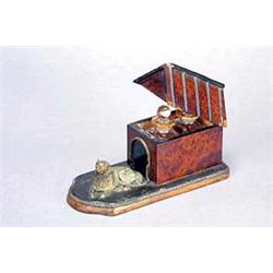 A 19th century amboyna and ebonised box in the form of a kennel, with an embossed gilt metal recu...