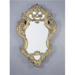 An early 19th century Italian giltwood wall mirror of cartouche shape carved with scrolls and fol...