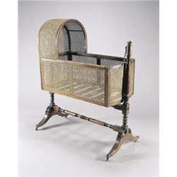 A George IV mahogany child's cradle, with caned arched hood and sides and a slatted base, the tur...