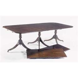 A mahogany three pillar dining table in Regency style with two loose leaves, the top with rounded...