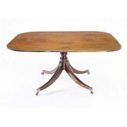 A Regency mahogany breakfast table, the rectangular tilt top with rounded corners and an ebony st...