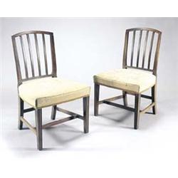A set of four late George III mahogany dining chairs, each with an arched back with vertical slat...