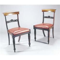 A set of four William IV rosewood dining chairs, each with a curved crest and scroll carved back...