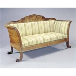 A Continental walnut sofa in early 19th century style, with an architectural crest flanked by car...