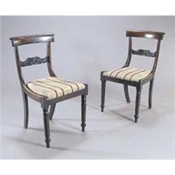 A set of six William IV rosewood dining chairs, each with a curved and scroll carved crest rail,...