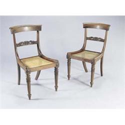 A set of eight William IV mahogany dining chairs, each with a curved crest and scroll carved back...