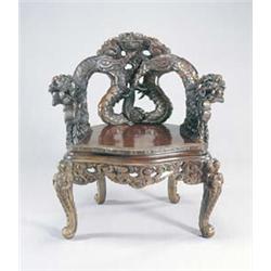 A 20th century Chinese elbow stained wood elbow chair, the curved back carved with dragons chasin...