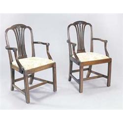 A pair of mahogany elbow chairs, each with a lobed crest above a pierced and carved splat, with s...