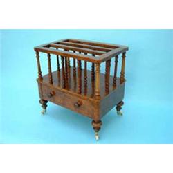 A Victorian walnut music canterbury with 3 divisions supported by turned pillars over single long...