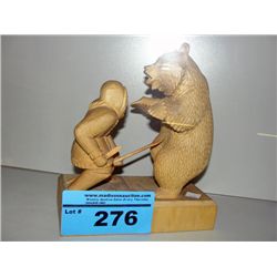 Carved wooden bear and hunter figurine