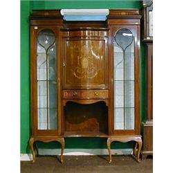An Edwardian inlaid mahogany display cabinet the centre section of serpentine outline enclosed by...