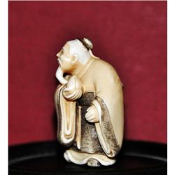 Ivory netsuke of a bearded man singed.