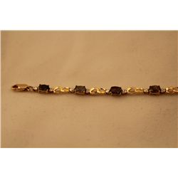 STAMPED 10K YELLOW GOLD ALEXANDRITE BRACELET. CENTER WEIGHT: 3.30 CARAT. WEIGHT: 4.10 GRAMS. CENTER