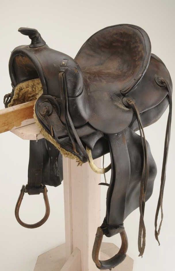 Fred Muellermarked leather bronc saddle; metal trimmed wood stirrups
