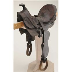 Half seat high back leather saddle, wood stirrups, no visible maker marks, overall fair to good well