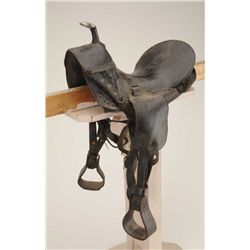 Child’s leather saddle with wooden stirrups in overall fair to good condition showing lots of even w